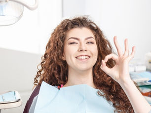 woman in dental chair giving her approval to the dentist