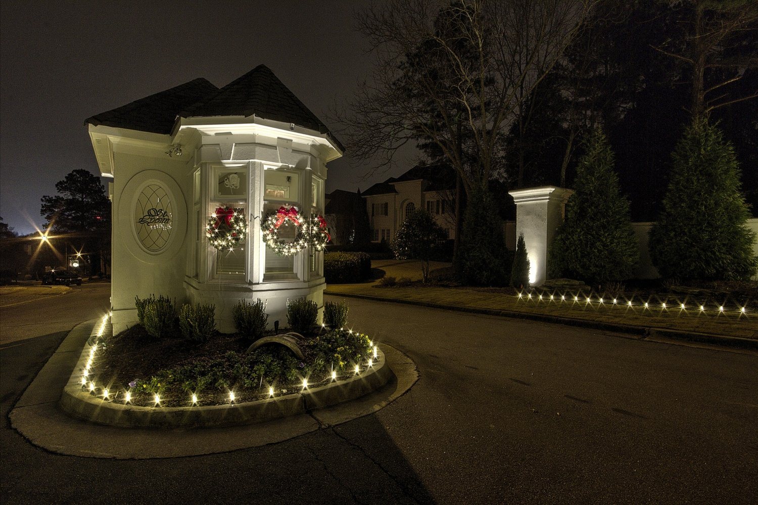 HOA entrance monument with Christmas lighting and garland