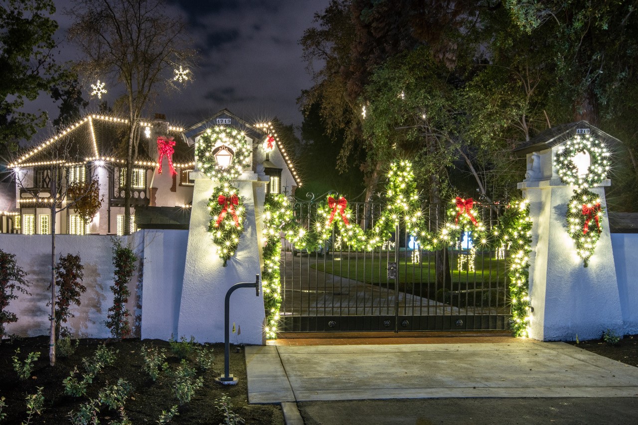 Home with gate and lit trees