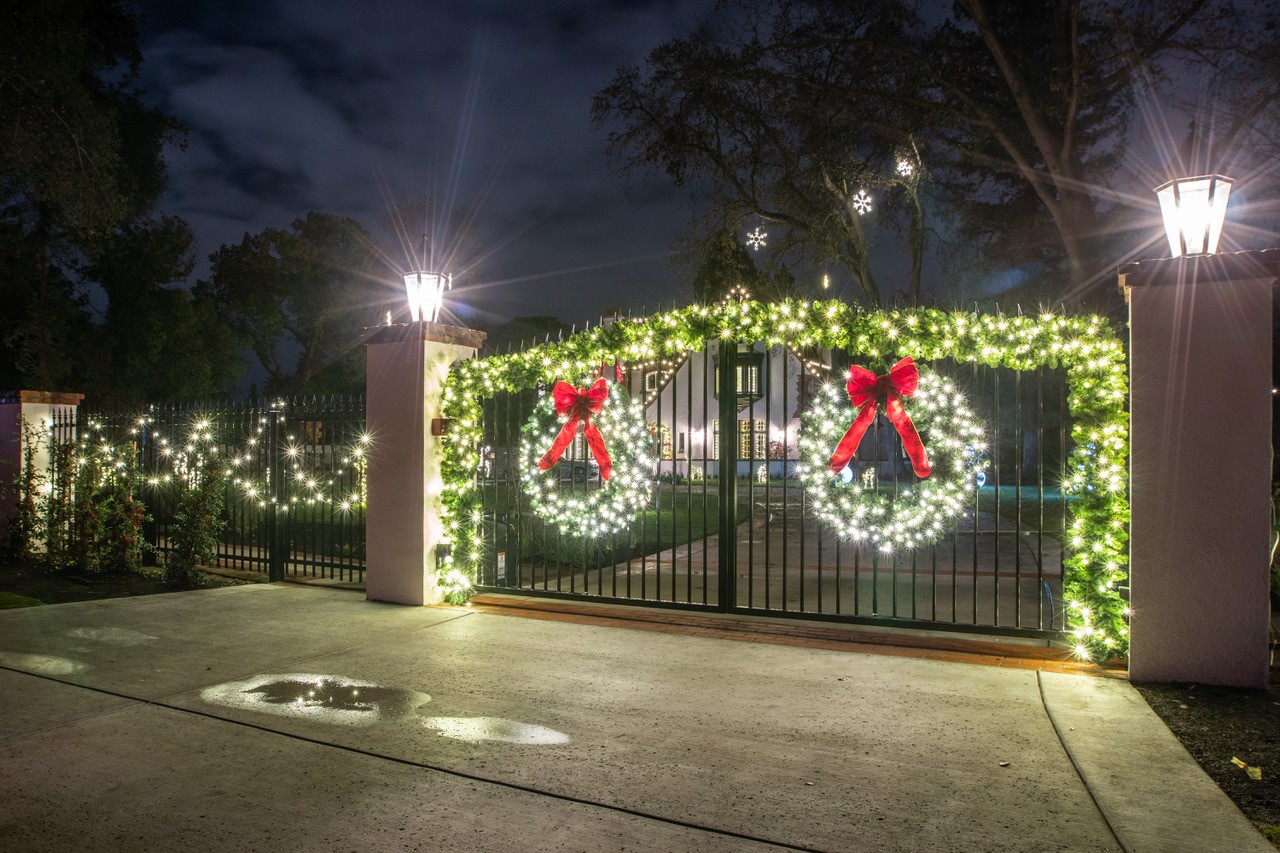 Gated entry with lit wreaths and garland