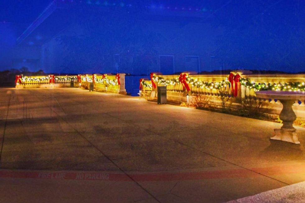 Neighborhood entrance with lighted garland and red bows