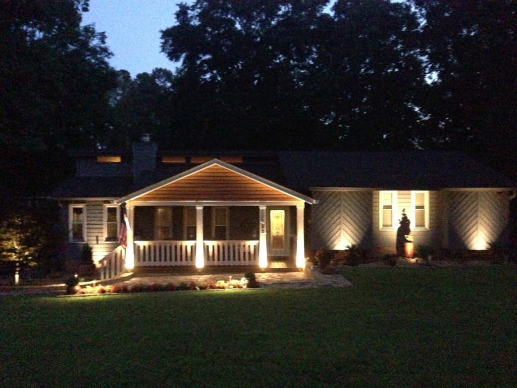 Low-voltage landscape lighting on a home and yard at night