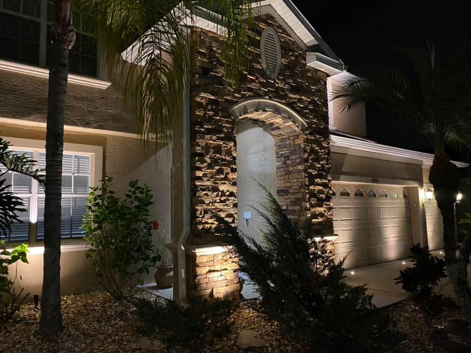Stone facade and entry with close-up landscape lighting