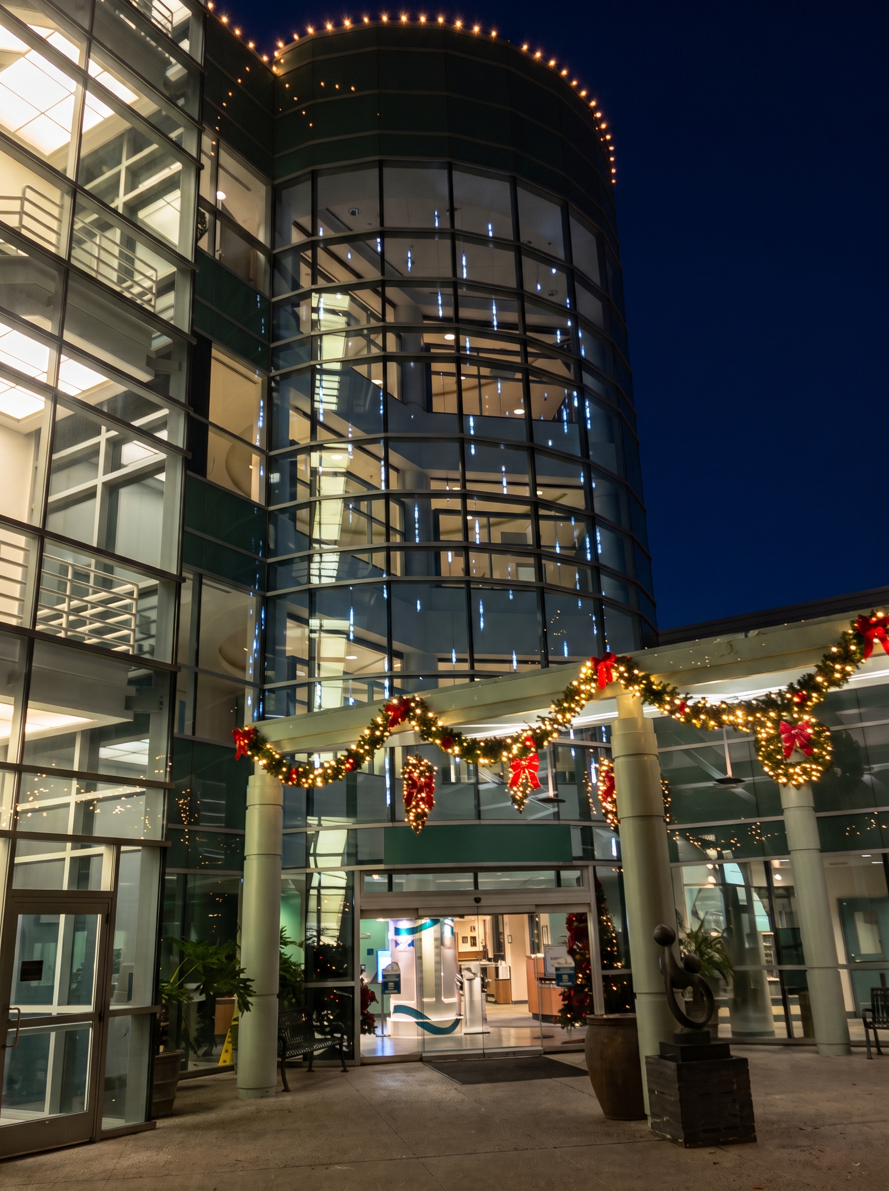 Glass building entry with holiday garland in Porterville