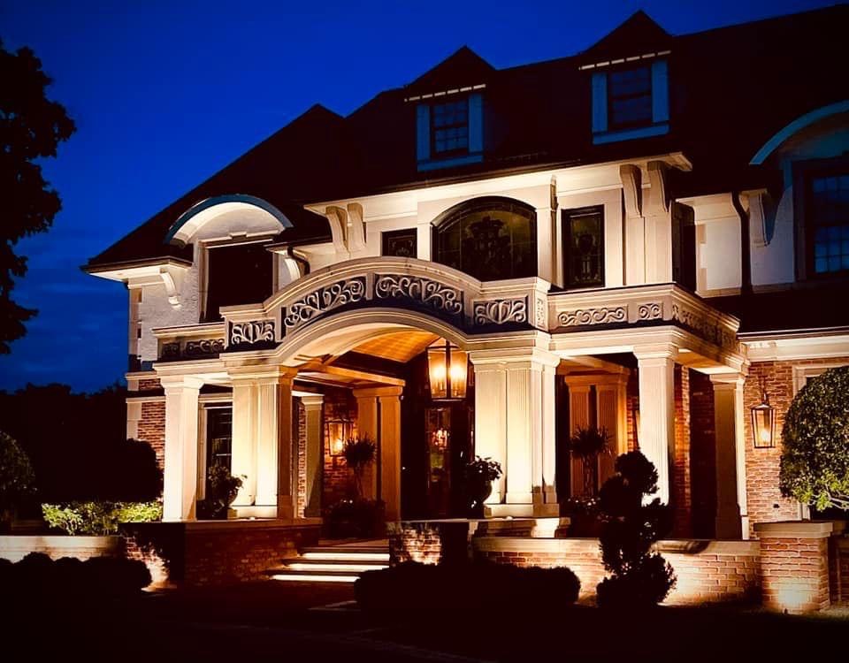 Grand home facade lit with architectural landscape lighting