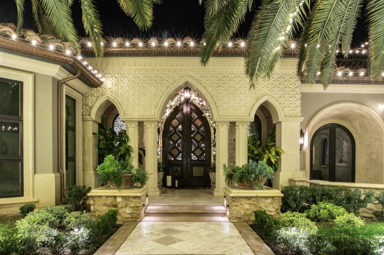 Arched entry with palms and holiday lighting