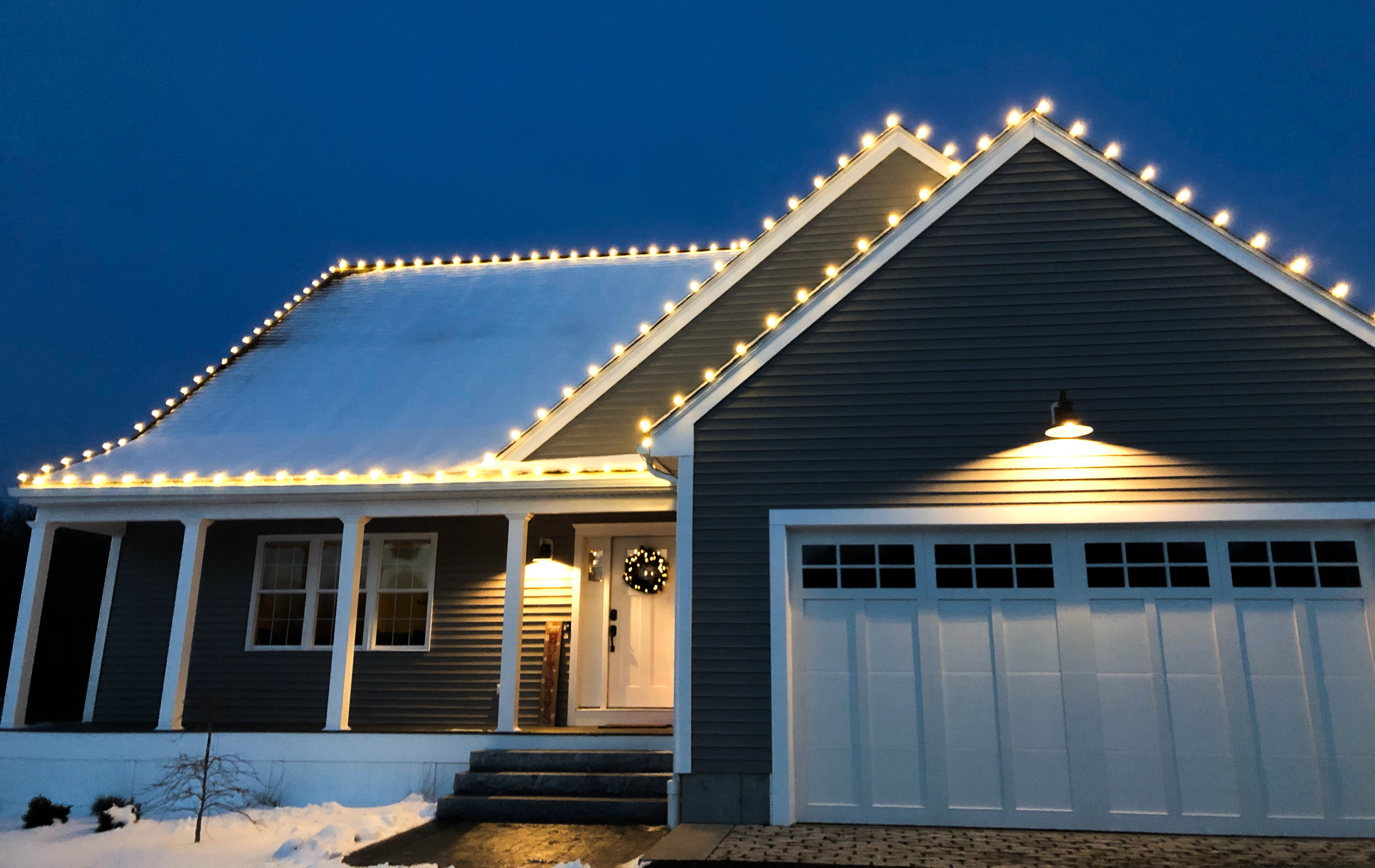 Permanent warm white LED lighting along a home's roofline and garage gable