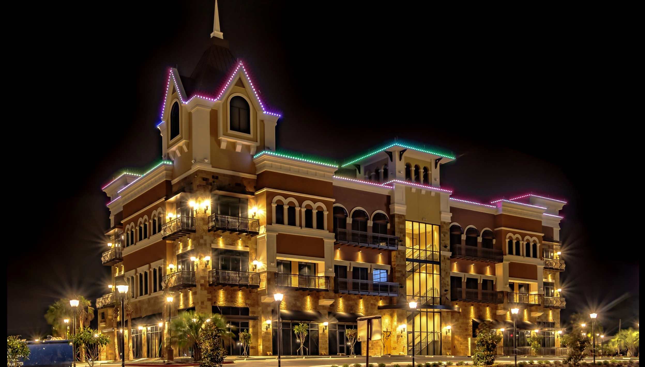 Permanent color lighting outlining a multi-story mixed-use building