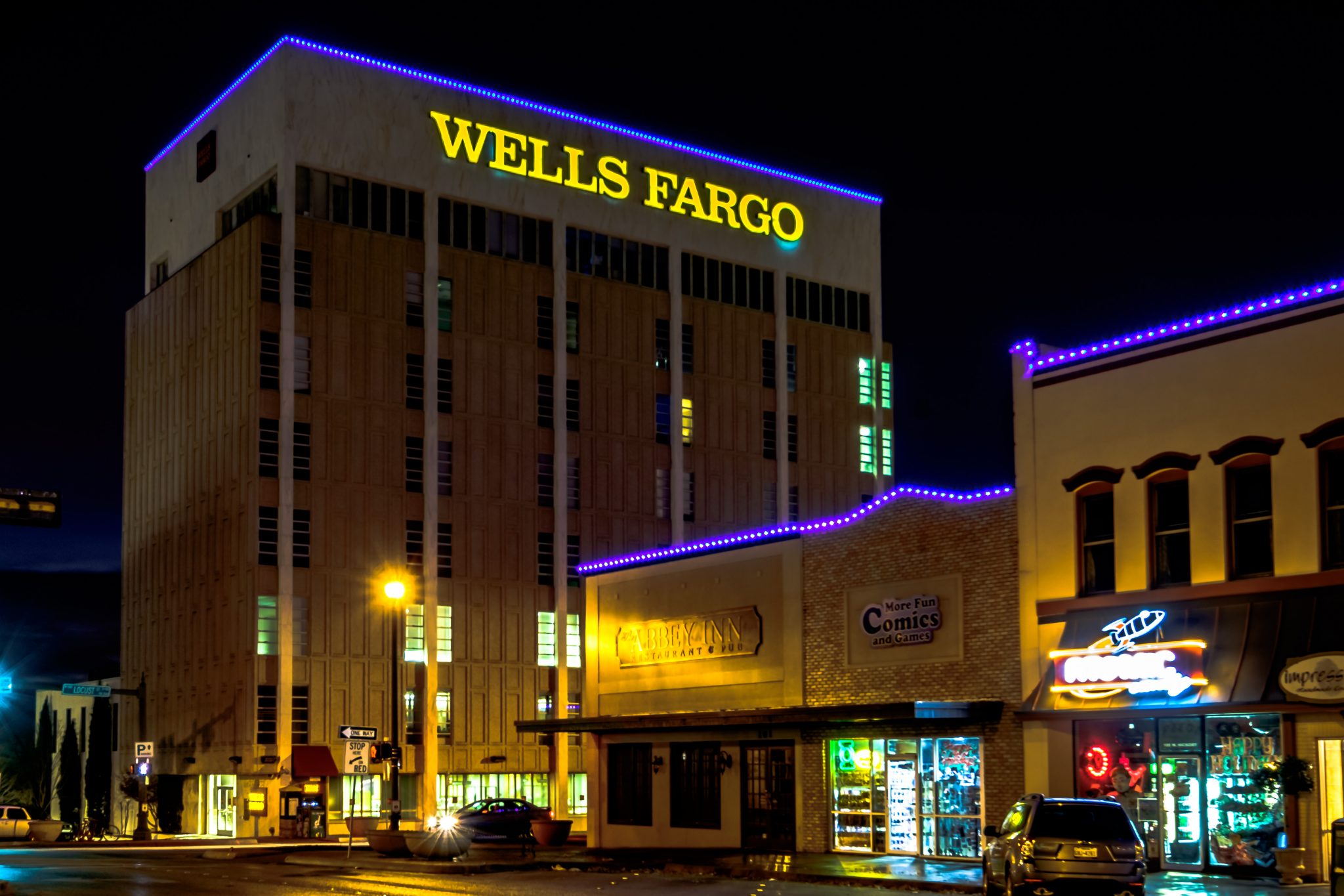 Permanent purple LED lighting along a downtown office tower and storefronts