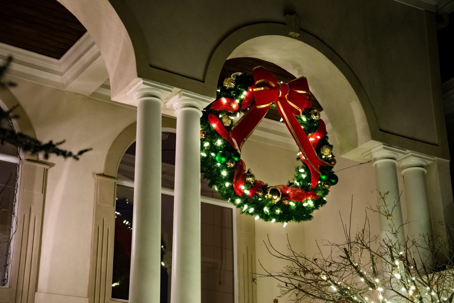 Lighted wreath and garland holiday décor at a building entrance