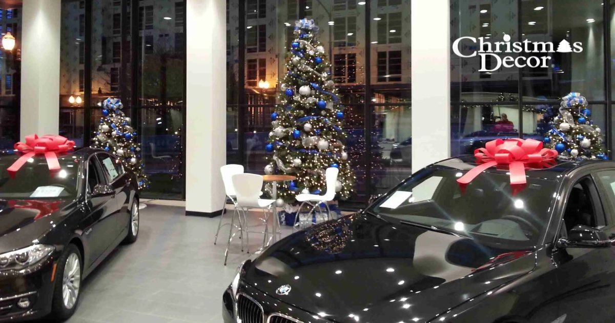 Car dealership showroom decorated with Christmas trees and bows