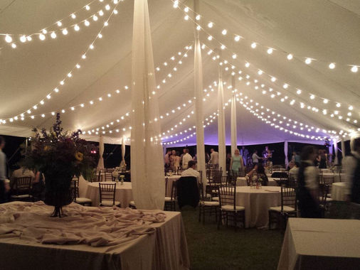 Wedding tent with bistro string lights and draped fabric