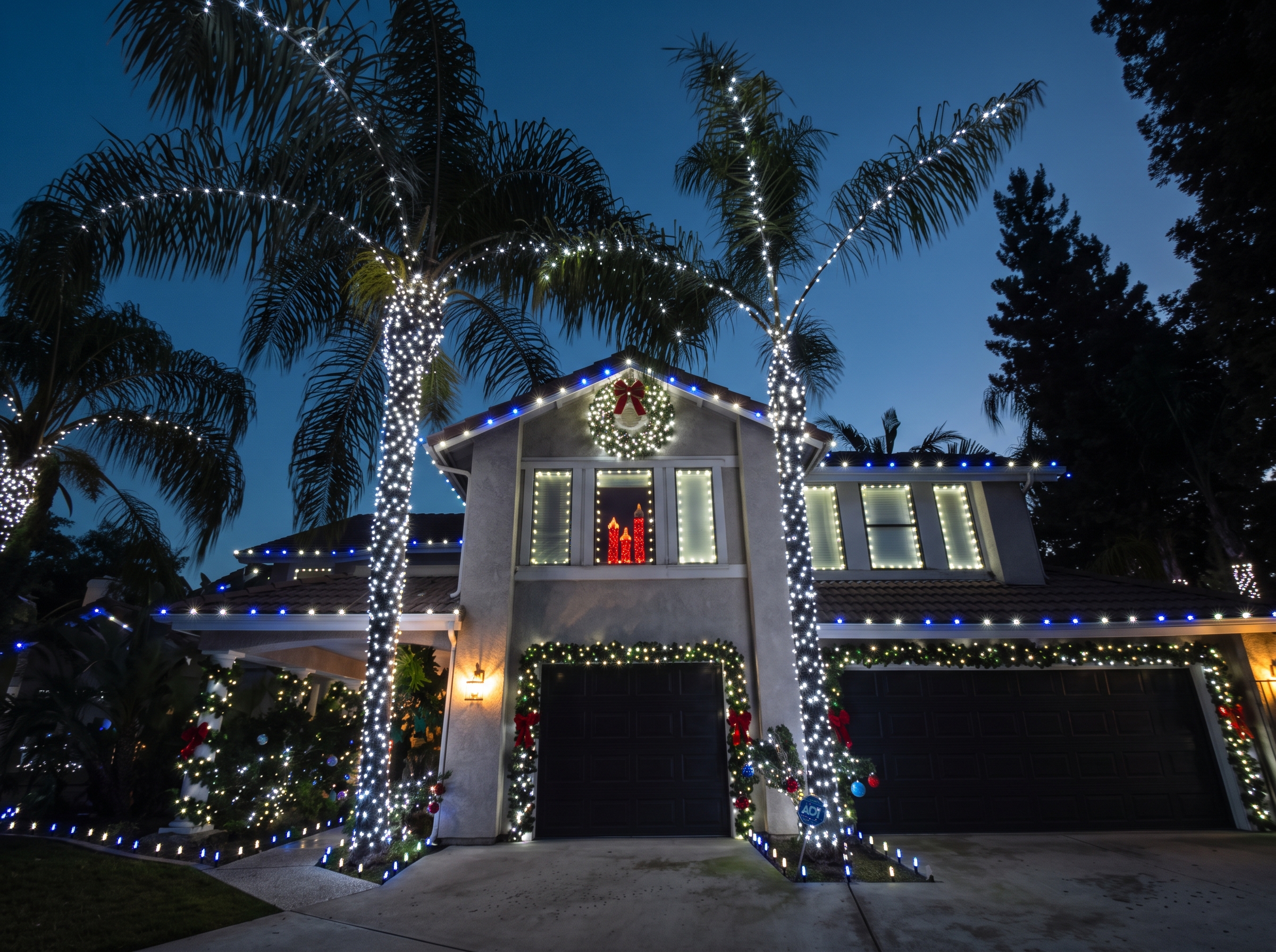 Christmas lights on a Visalia home with wrapped palms