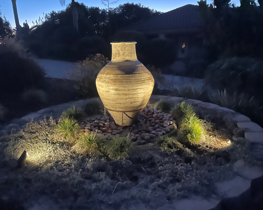 Garden urn uplit among drought-tolerant plantings