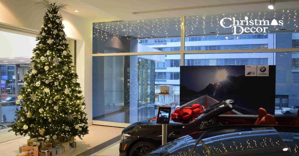 Dealership showroom Christmas tree beside a display car