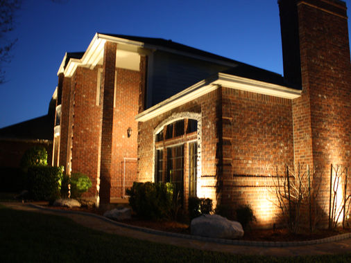 Brick home with architectural uplighting at dusk