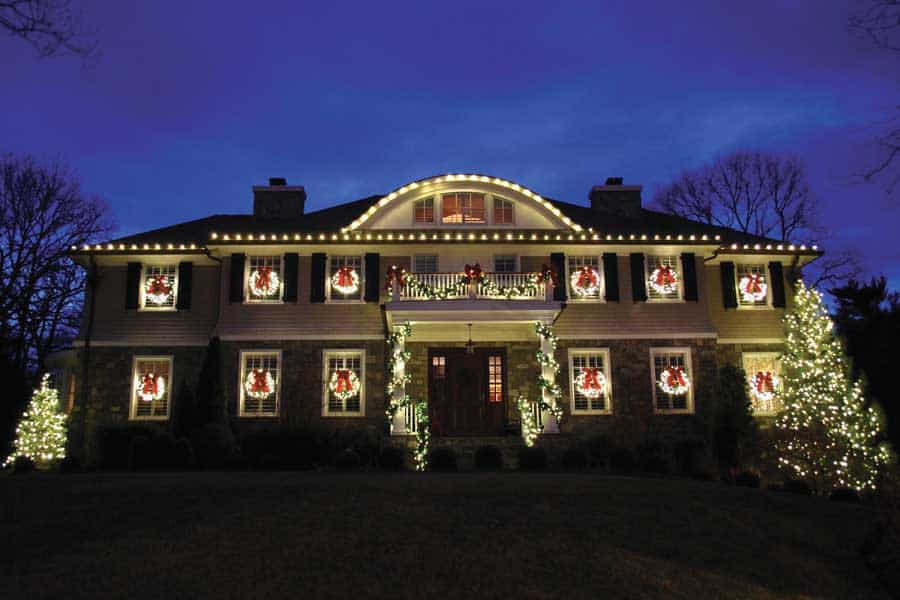 Professionally installed Christmas lights on a home roofline at night