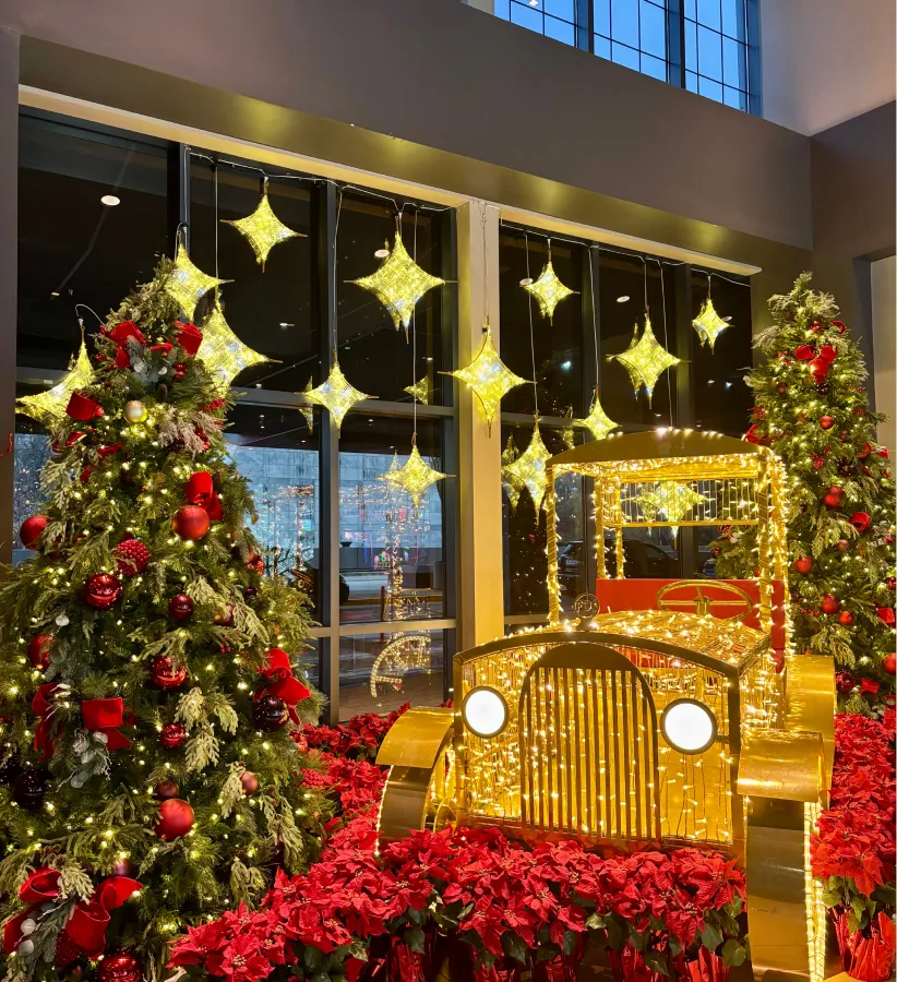 Commercial lobby with Christmas trees, poinsettias and gold star décor