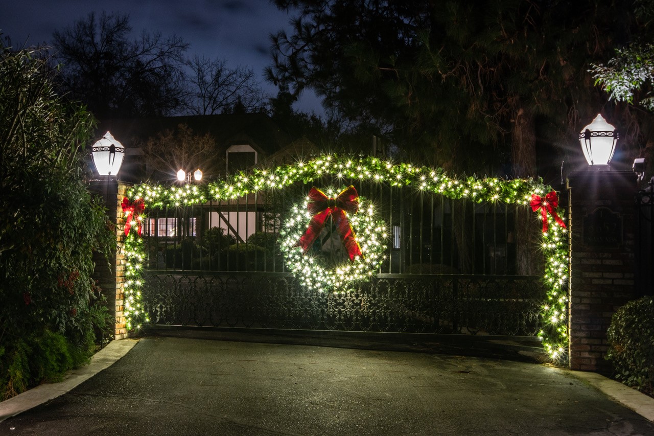 Gated estate entry with a lit wreath
