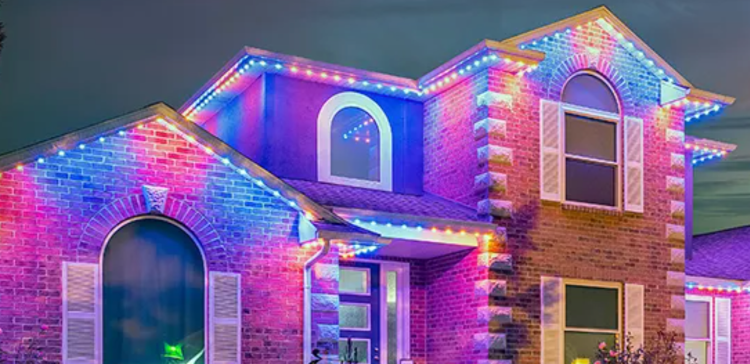 Brick home with multicolor permanent roofline lighting