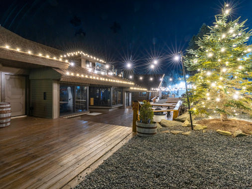 Commercial walkway with roofline lights and a lit Christmas tree