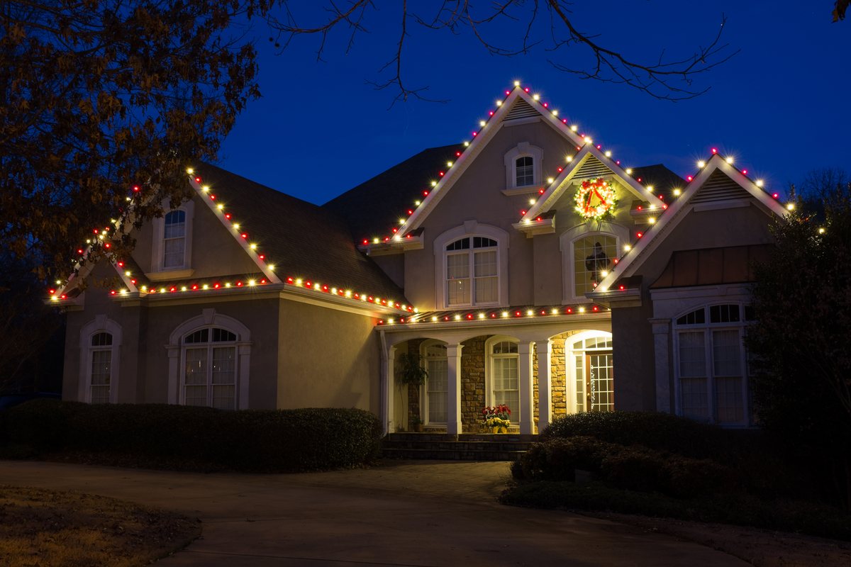 Professionally installed Christmas lights on a home roofline at night