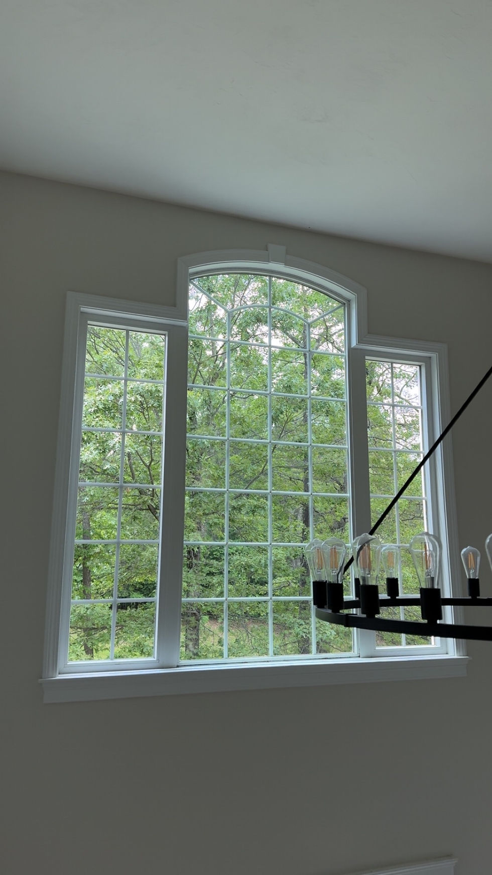 Large clean window behind a chandelier in a dining room