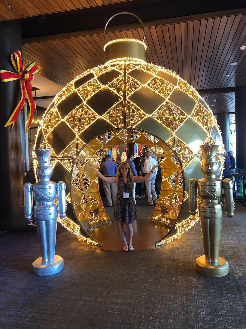 Visitors standing inside a giant lit ornament holiday photo display