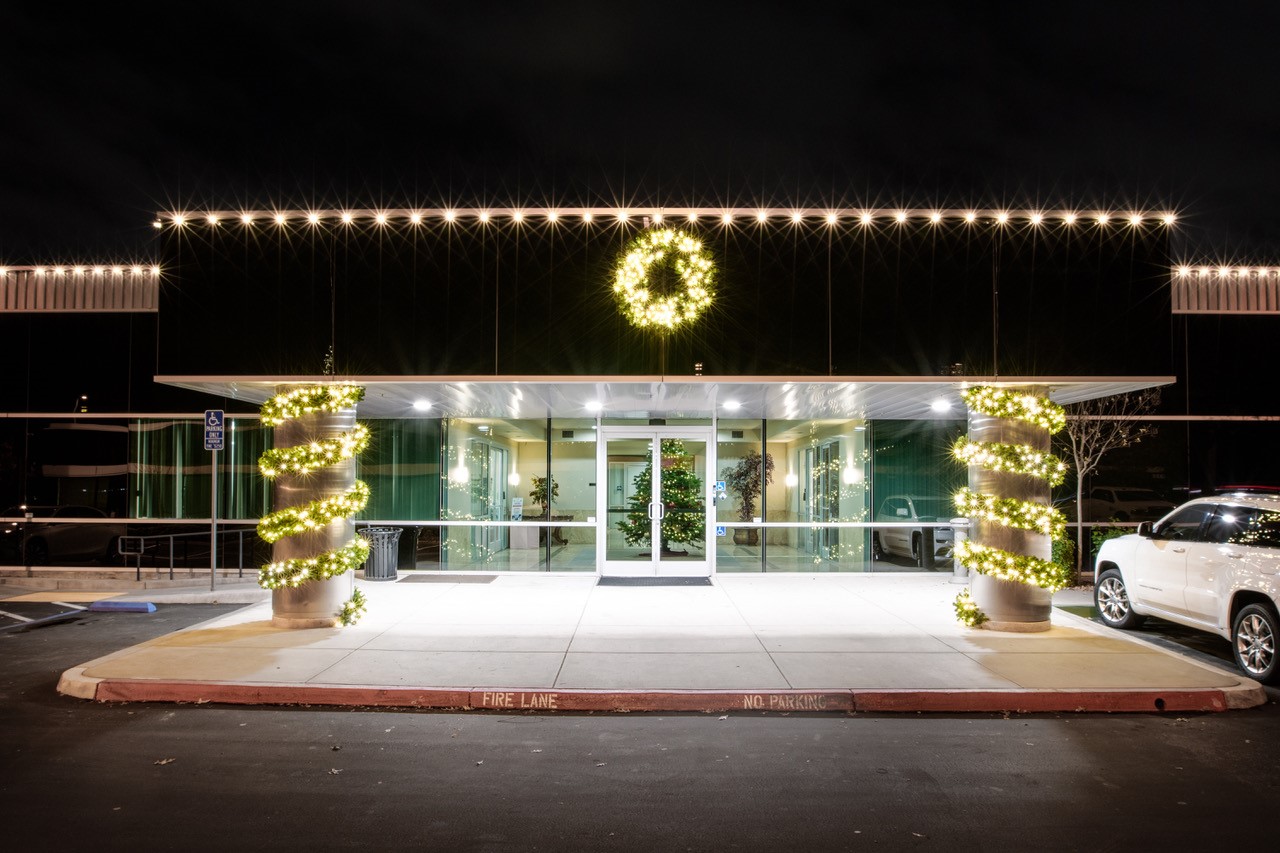 Commercial entry with roofline lights, a wreath and lit columns