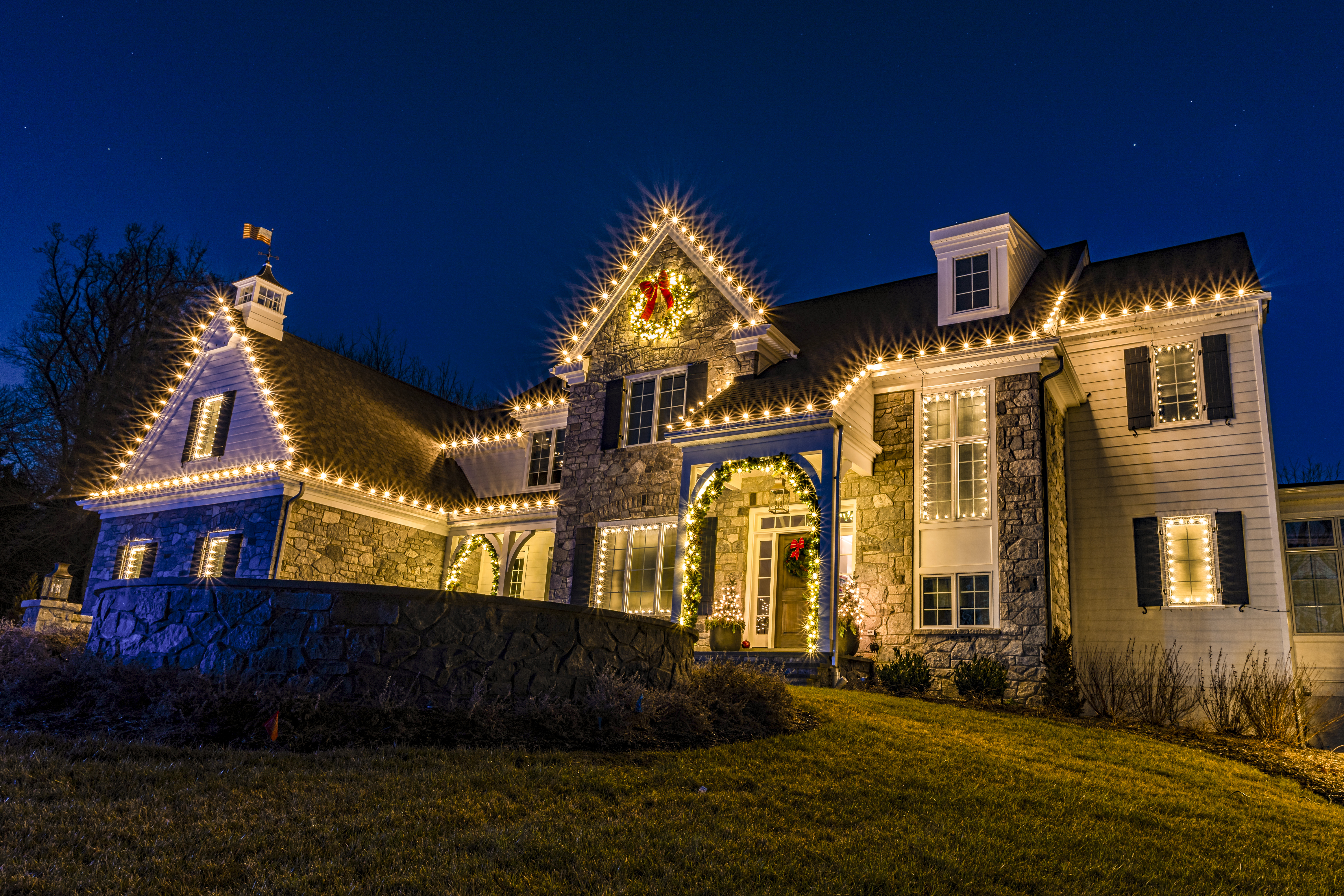 Large home with a warm-white roofline at blue hour