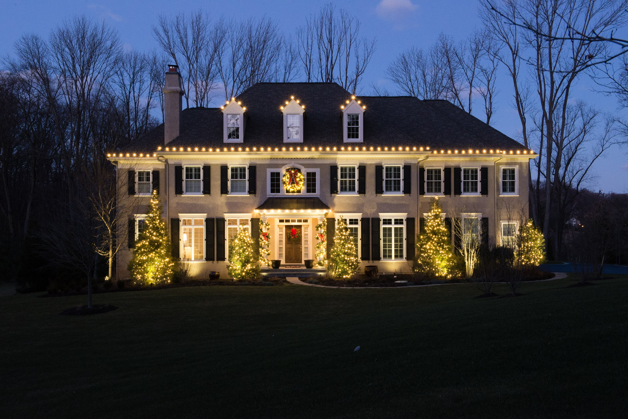 Low-voltage landscape lighting on a home and yard at night