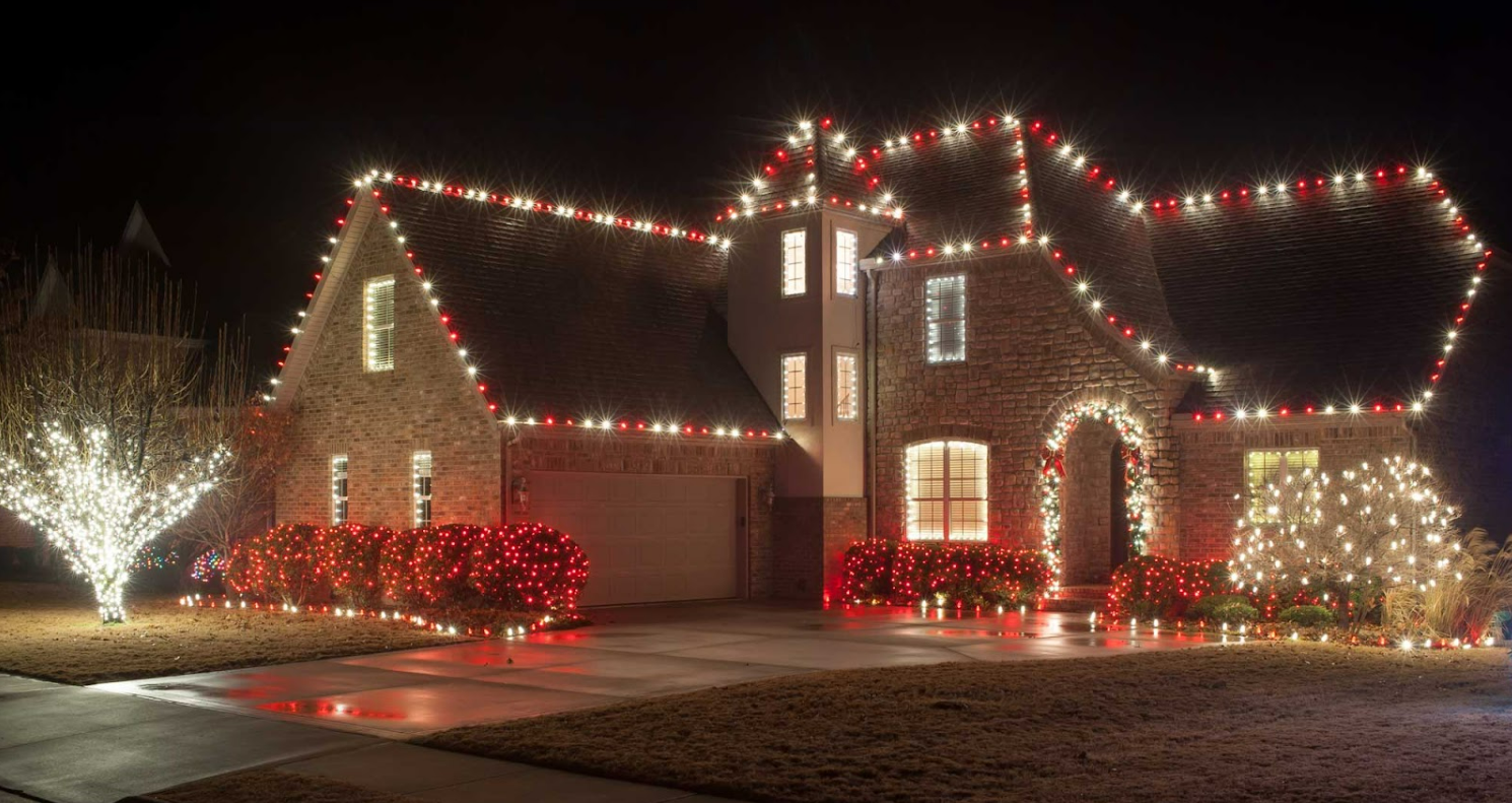 Professionally installed Christmas lights on a home roofline at night