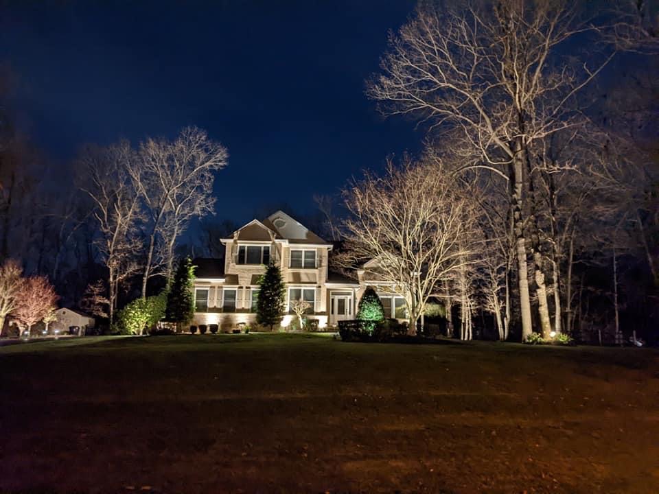 Low-voltage landscape lighting on a home and yard at night