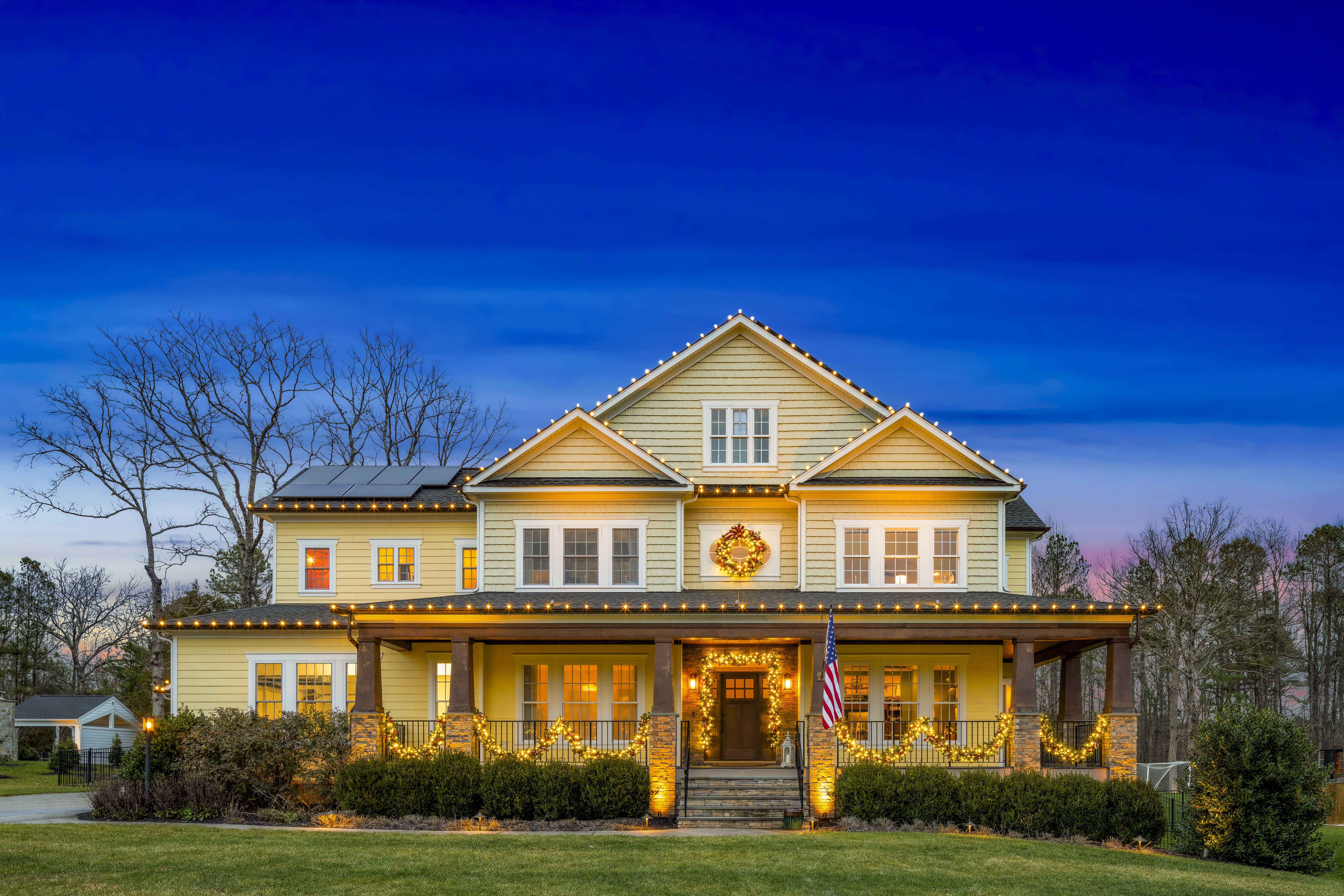 Home with a warm-white roofline at twilight