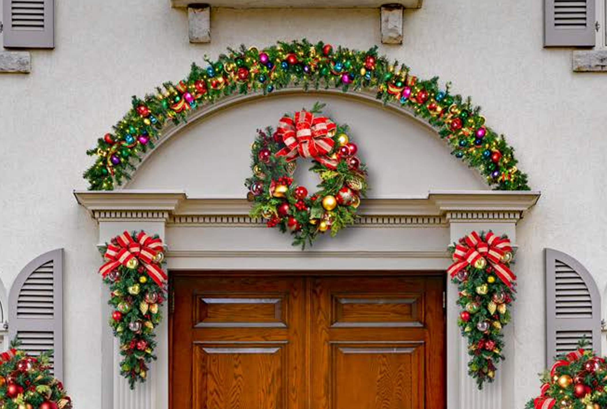 Lighted wreath and garland holiday décor at a building entrance