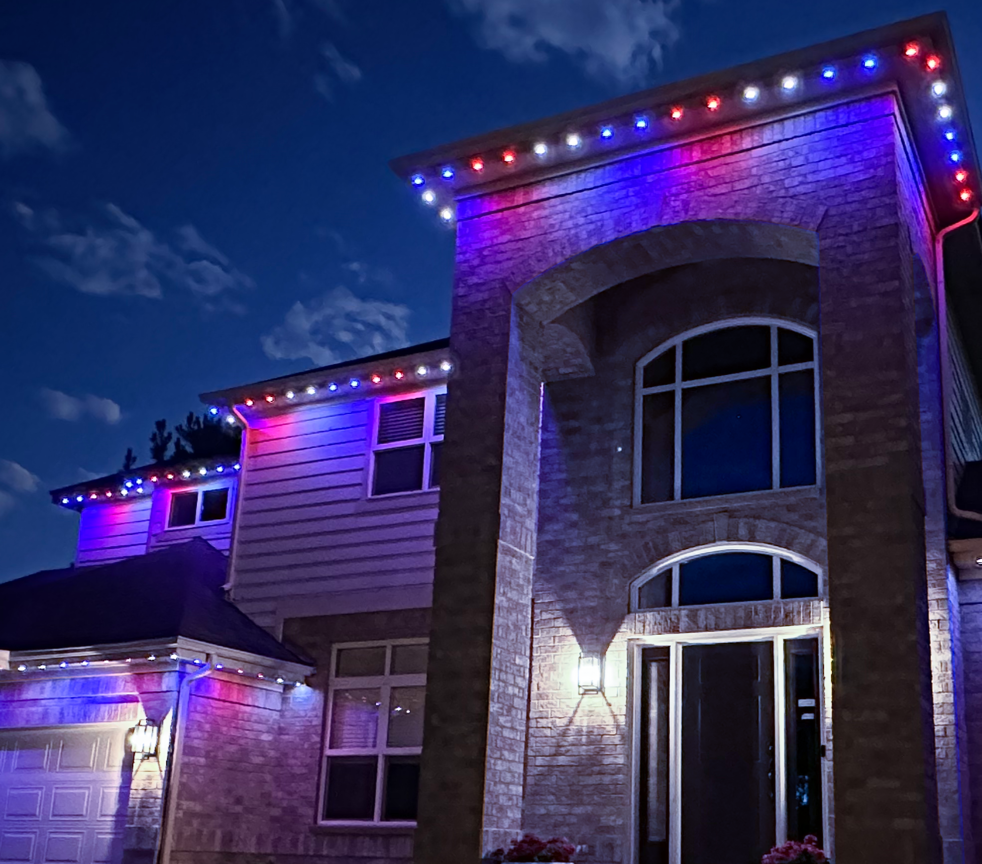 Two-story home with permanent lighting in red and purple