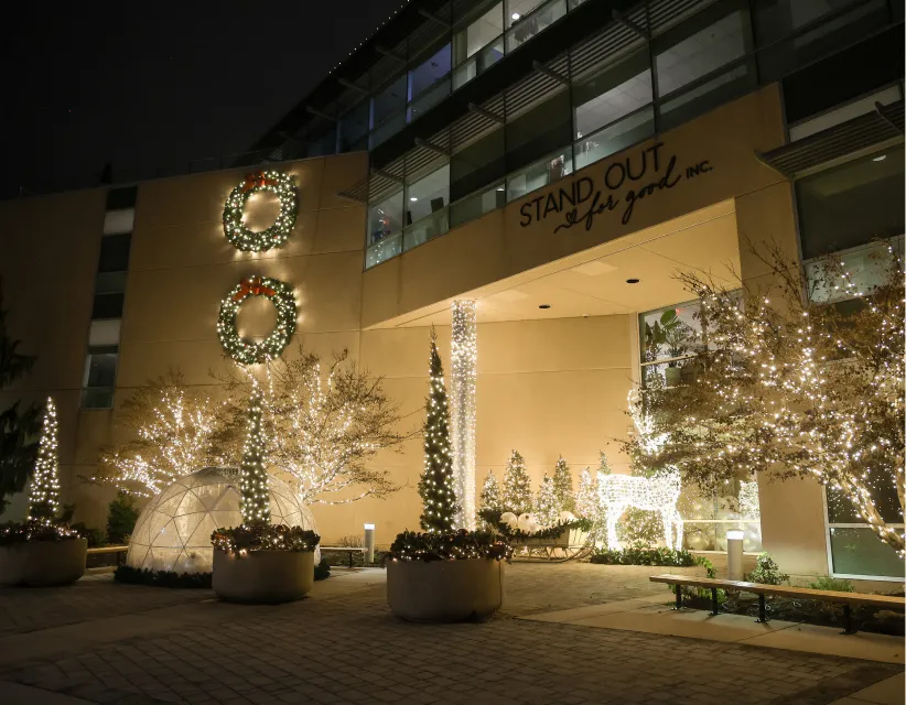 Office building entrance with lighted trees and holiday planters
