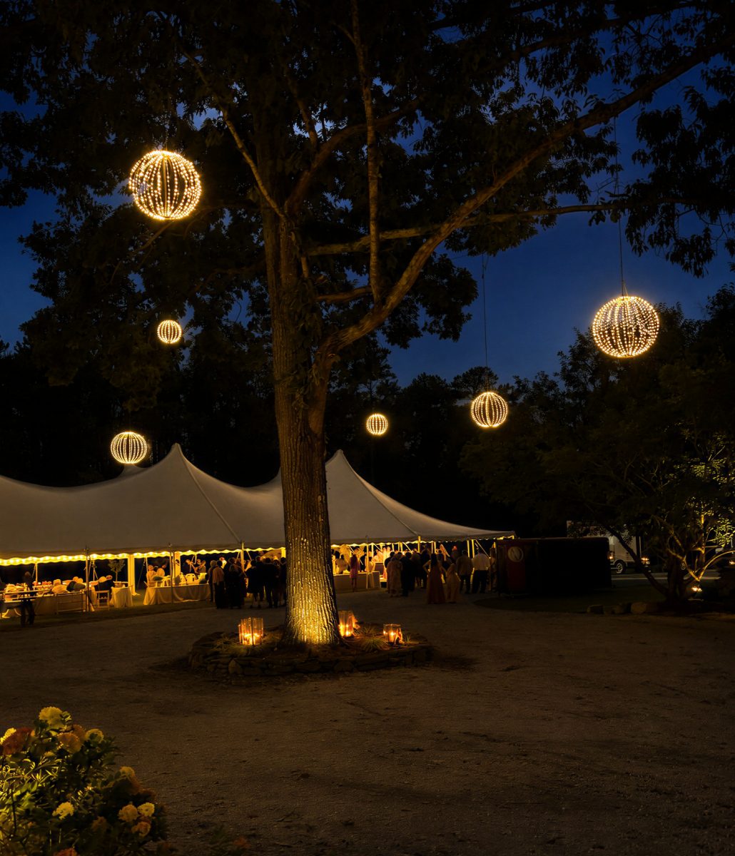 Glowing light globes hung in trees over an outdoor event lawn