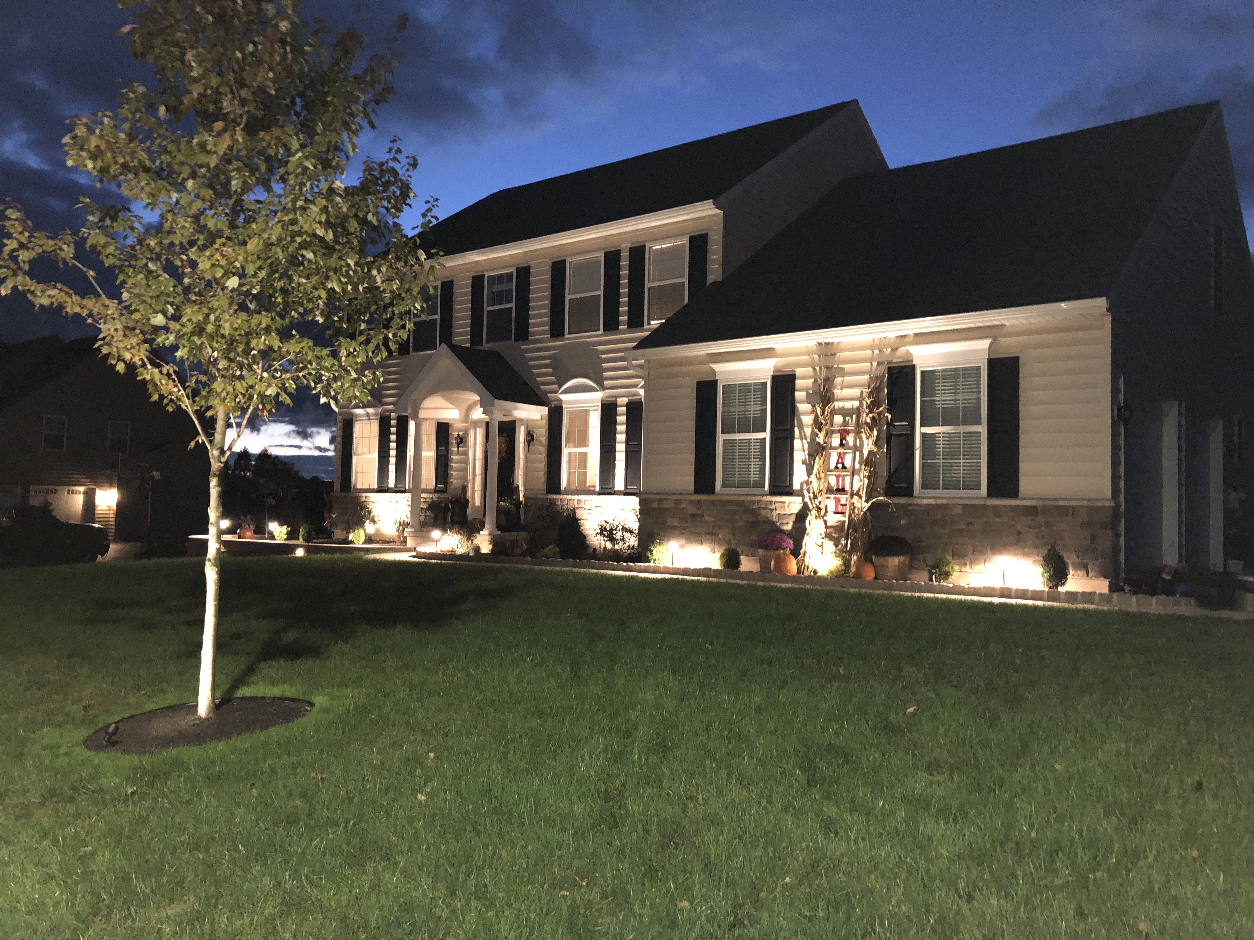 Low-voltage landscape lighting on a home and yard at night