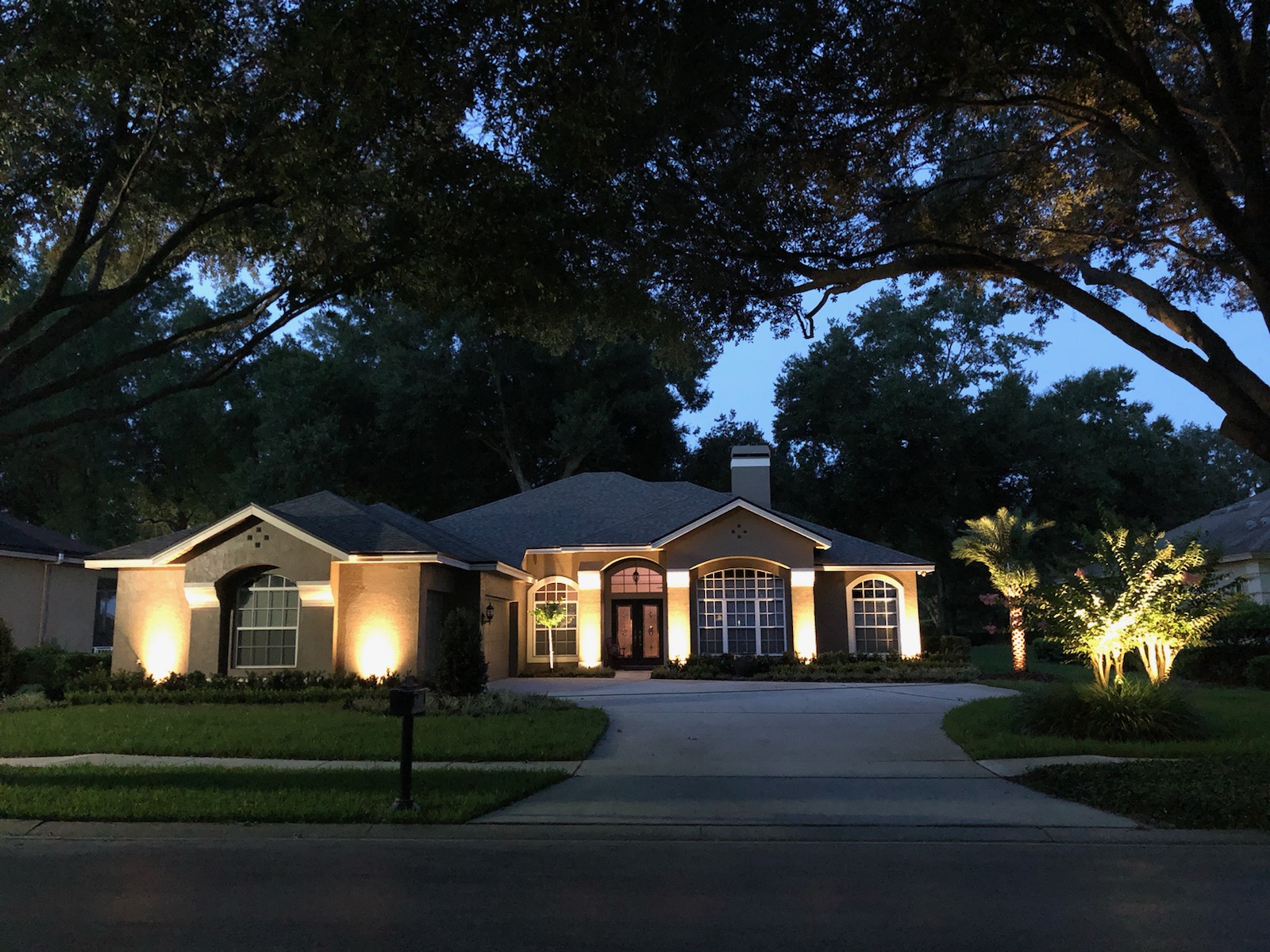 Low-voltage landscape lighting on a home and yard at night