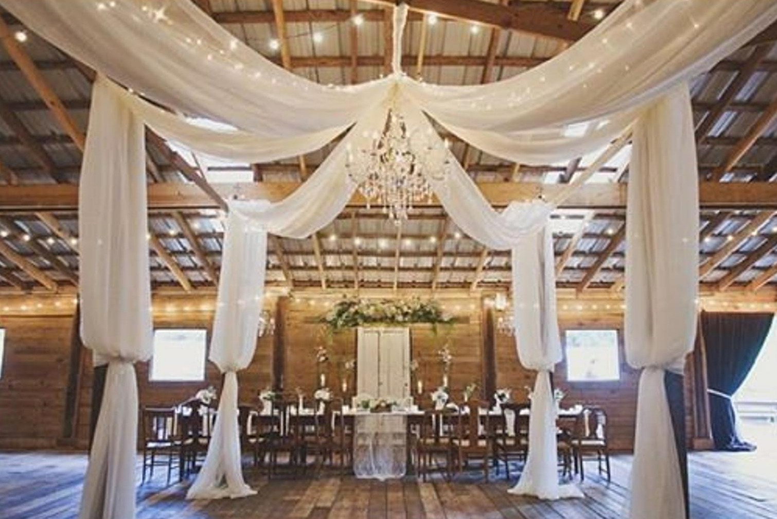 Barn wedding with draped fabric and lights