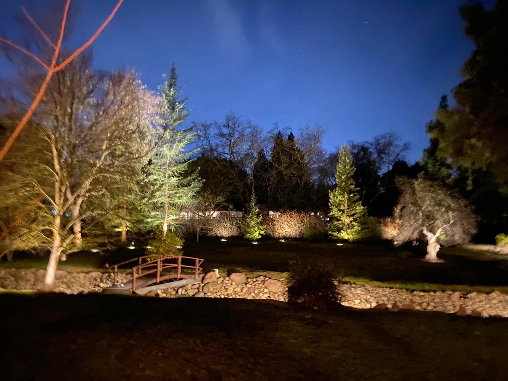 Low-voltage landscape lighting on a home and yard at night