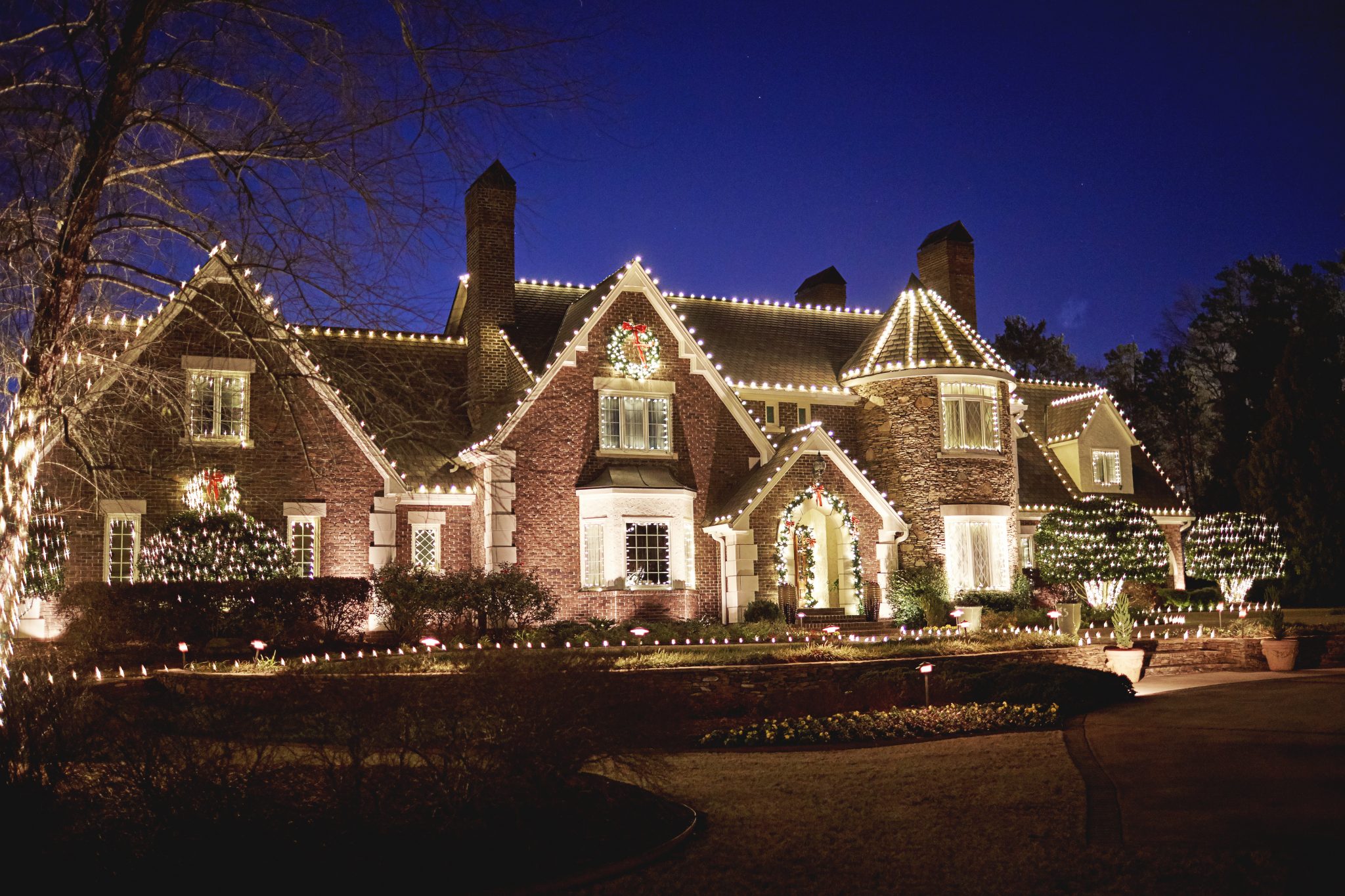 Professionally installed Christmas lights on a home roofline at night