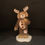 Thumbnail: Dog in a reindeer costume holding a  teddy bear figurine front view