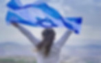 ISRAEL IS OUR HOME picture of girl holding Israel flag against the wind