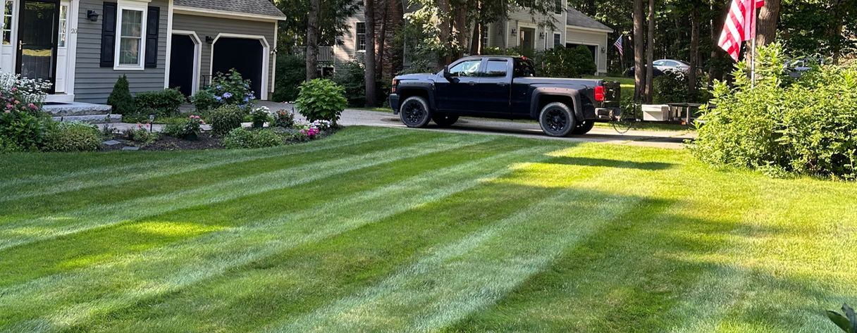 Professional lawn care and mowing with crisp striped patterns by Recon Landscaping in Kennebunk, Maine