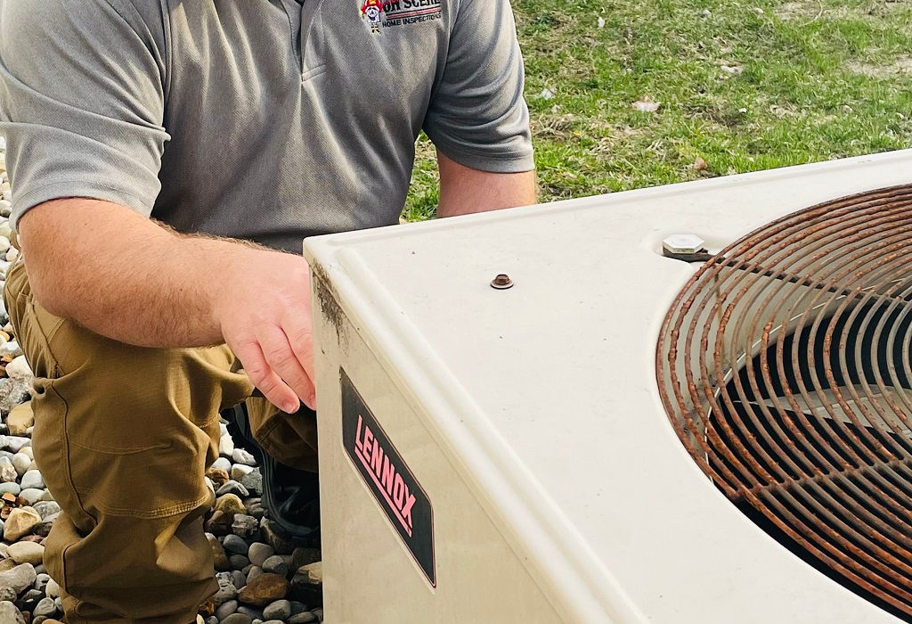 home inspector looking at outdoor HVAC unit