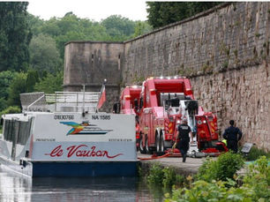 Un camion rotator Mecano Service F.c qui tire un bateau à la dérive