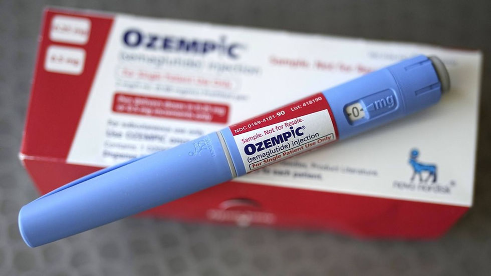 Un stylo injecteur d'Ozempic bleu posé sur sa boîte d'emballage rouge et blanche du laboratoire Novo Nordisk.