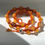Thumbnail: Handmade macrame wrap bracelet in orange with Tibetan silver flower beads 